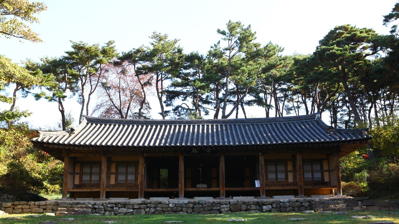 고창읍성 안쪽의 긴 목조건물과 낮은 돌기단, 뒤편의 소나무