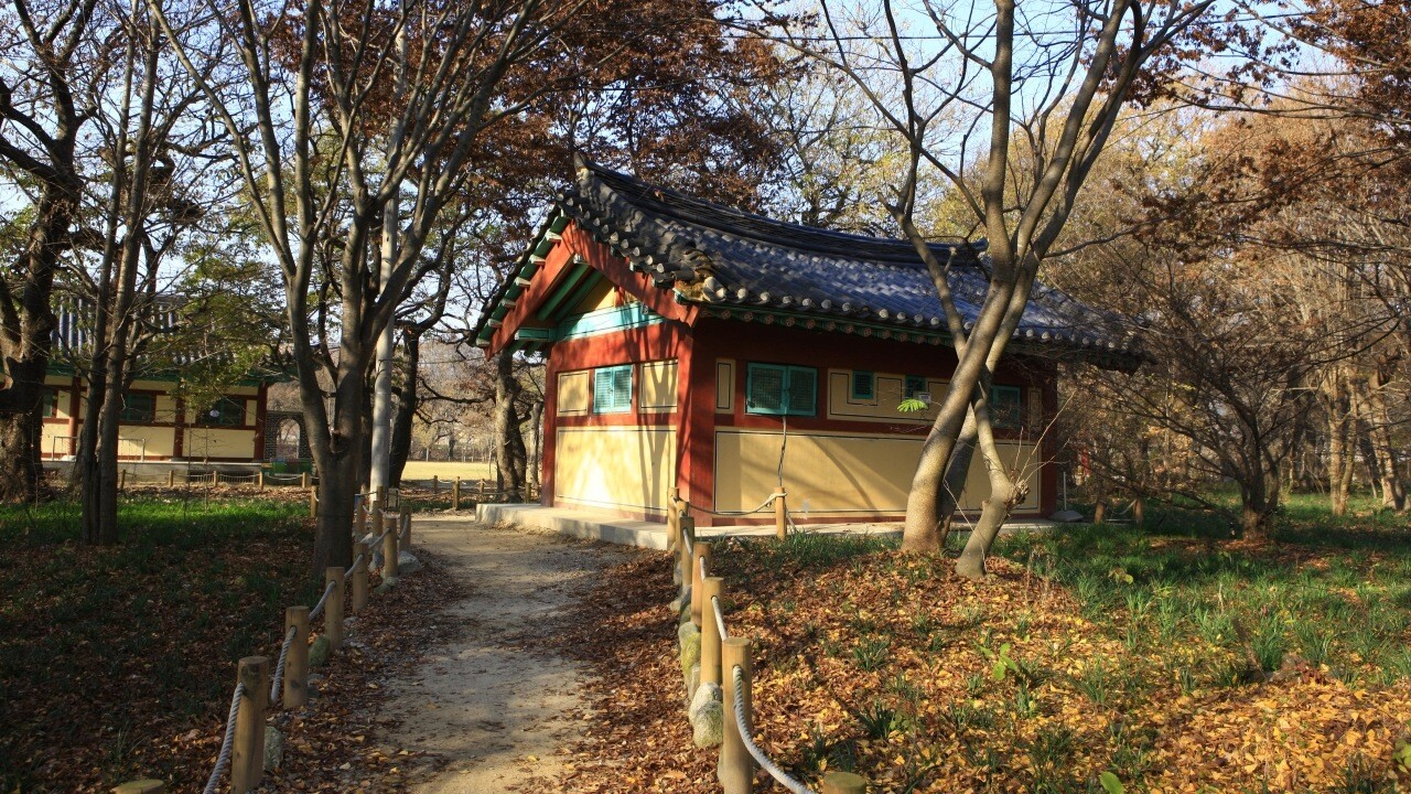 상림공원 숲길 옆의 작은 기와 건물과 주변 나무