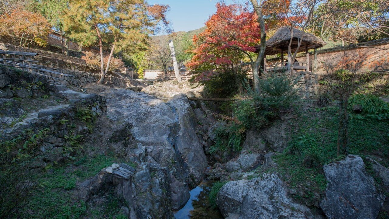 담양 소쇄원의 바위 계곡과 그 가장자리에 놓인 누정, 붉은 가을 나무