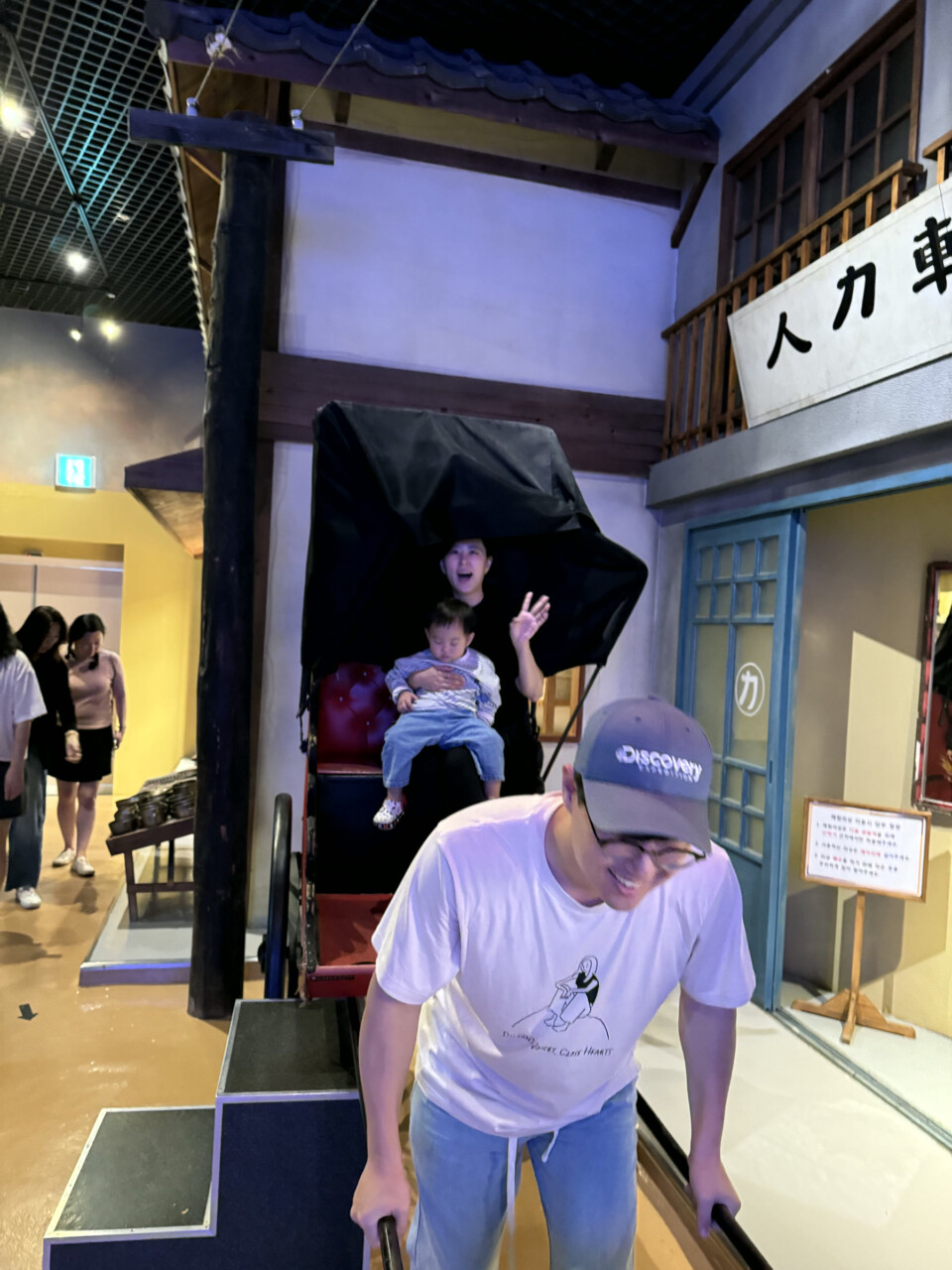 아이와 가족이 군산 근대역사박물관 인력거를 체험하는 모습